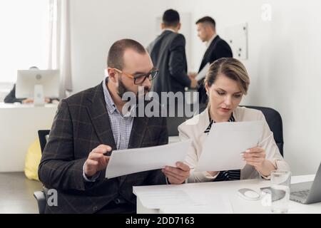 Ein erfahrener Senior Manager erklärt einem neuen Mitarbeiter die Nuancen seiner Arbeit. Hinweise, Tipps und Schulungen. Stockfoto