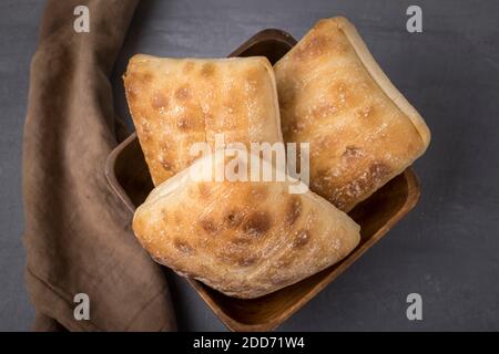 Ein Überblick über ein Studiofoto von Ciabatta Brot in einer Holzschale. Stockfoto