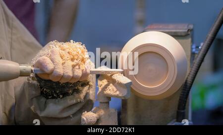 Zimmermann mit Meißel zum Formen von Holzstücken auf der Drehbank - Nahaufnahme Stockfoto