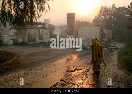 KEIN FILM, KEIN VIDEO, KEIN TV, KEINE DOKUMENTATION - Vista Fire Department Captain Ned Vander Pol trägt einen Schlauch weg von einem Haus in Rancho Santa Fe, Kalifornien, das durch ein Feuer am Dienstag, den 23. Oktober 2007 zerstört wurde. Foto von Randy Pench/Sacramento Bee/MCT/ABACAPRESS.COM Stockfoto