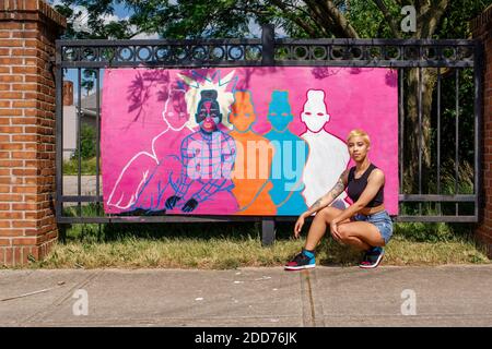 Eine junge Künstlerin sitzt stolz vor ihr Straßenmalerei Stockfoto