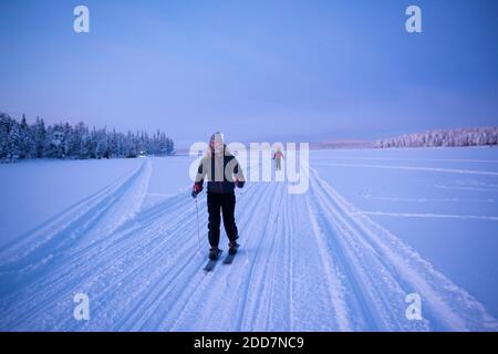 Skifahren auf dem gefrorenen See bei Torassieppi bei Sonnenuntergang, Lappland, Finnland Stockfoto