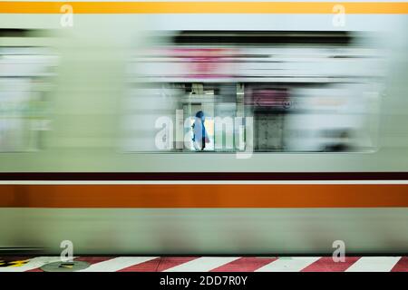 Mann an einer U-Bahn-Station als Zug fährt in Tokio, Japan Stockfoto