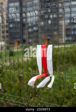 Weiß-rot-weiße Bänder am Zaun. Weiß-rot-weiße Flagge. Stockfoto