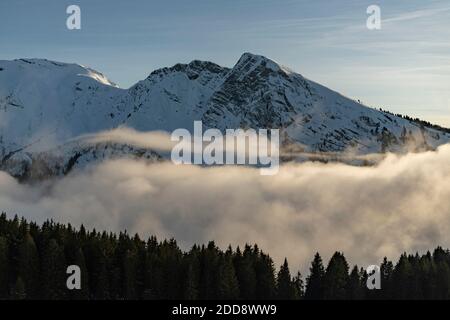 Dramatische Bergspitzen und niedrig liegender Nebel und Wolken im wunderschönen Sonnenuntergangslicht im Skigebiet Avoriaz, Frankreich, Europa Stockfoto