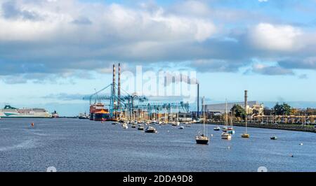 Dublin Port, Irland, mit einem Portalkran in Betrieb, einer Fahrgastfähre mit Liegeplätzen, kleinen Booten und der East Link Ferry Bridge und der neuen i Stockfoto