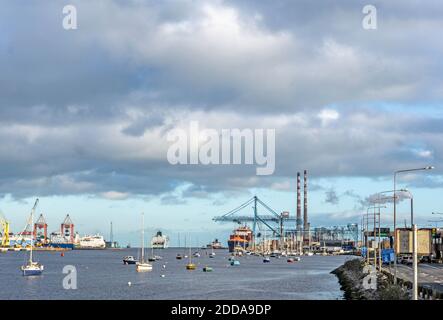 Dublin Port, Irland, mit einem Portalkran in Betrieb, einer Passagierfähre abfahrenden, kleinen Booten und der East Link Ferry Bridge. Stockfoto