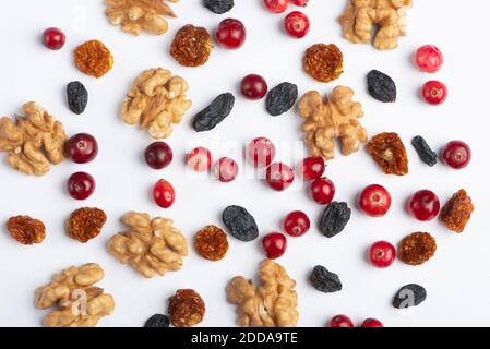 Getrocknete Preiselbeeren, Walnüsse, Rosinen, auf weißem Papier Hintergrund. Stockfoto