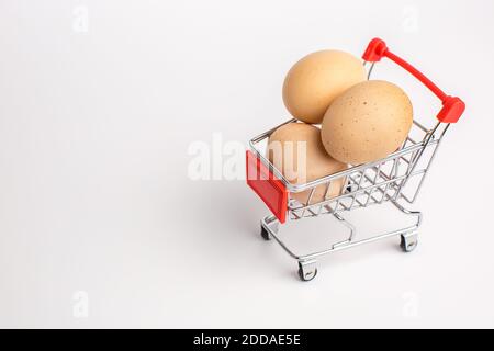 Beige Hühnereier im Warenkorb. Weißer isolierter Hintergrund. Gesunde Ernährung Konzept. Stockfoto