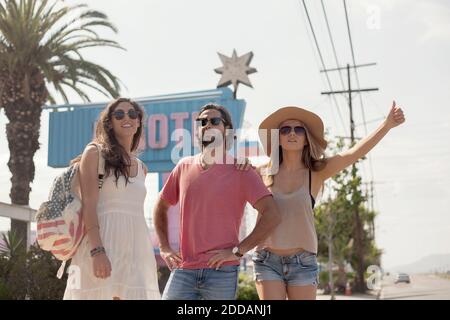 Männliche und weibliche Freunde in Sonnenbrillen, die eine Fahrt während Sonniger Tag Stockfoto