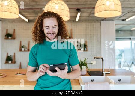 Schöner Mann mit digitalen Tablet, während in Studio-Wohnung stehen Stockfoto
