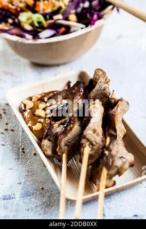 Thai-Stil Huhn mit Erdnusssauce und Kohlsalat auf Tisch im Freien Stockfoto