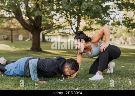 Frau motivierende Mann tun Liegestütze im Hinterhof Stockfoto