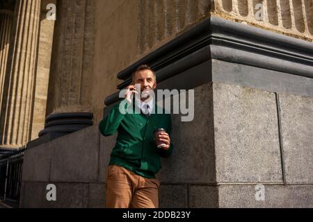 Geschäftsmann im Gespräch auf Handy, während sich auf Säule der Kasan Kathedrale in Sankt Petersburg, Russland Stockfoto