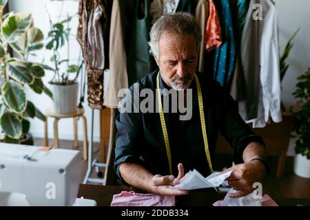 Maßgeschneidertes Kontrollieren von Stoffmuster im Arbeitsstudio Stockfoto