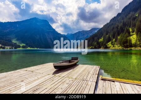 Ruderboot links am Rand der Anlegestelle am Ufer des Vilsalpsee see Stockfoto