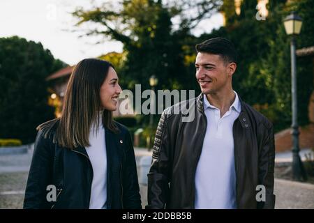 Lächelnder Mann und Frau tragen Jacke und gehen auf der Straße Stadt Stockfoto