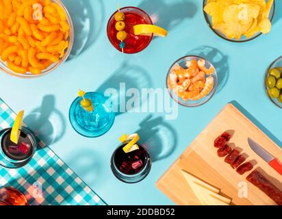 Blue Table Set mit verschiedenen Snacks, Vorspeisen und Cocktails Stockfoto