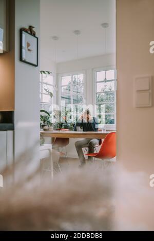 Deprimierter Mann mit Kopf in den Händen, der zu Hause sitzt Stockfoto