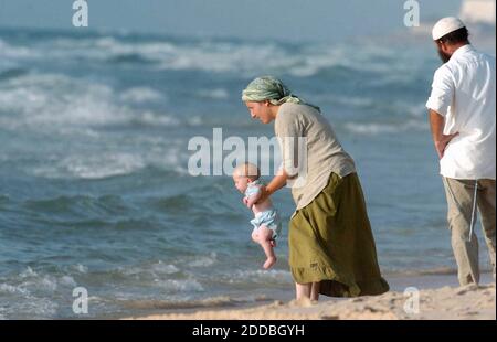 KEIN FILM, KEIN VIDEO, KEIN Fernsehen, KEIN DOKUMENTARFILM - eine israelische Frau spielt mit seinem kleinen Baby in der Siedlung Shirat Hayam am Strand, die auch als Zeltstadt bekannt wurde, im Siedlungsblock des Gazastreifens, Montag, 25. Juli 2005. Der Zustrom von Eifer, Idealistische Demonstranten könnten eine schwierige Herausforderung für Israel darstellen, wenn es nächsten Monat Pläne zur Schließung und zum Abbau aller 21 Siedlungen im besetzten Gazastreifen als Teil des umstrittenen Plans von Premierminister Ariel Sharon zur Verbesserung der Sicherheit seines Landes und zum Abbau der Spannungen mit Palästinensern plant. Foto von Yossi Zamir/Flash 90/KR Stockfoto