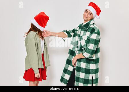 Ein Mann steht neben einer Frau Weihnachtsmütze Emotionen Urlaubsbeziehung Stockfoto