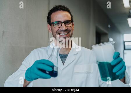 Wissenschaftler, der mit flüssiger Lösung auf dem Klinikkorridor steht Stockfoto
