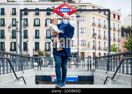 Mann trägt Gesichtsmaske zu Fuß trägt Baby verlassen U-Bahn Stockfoto