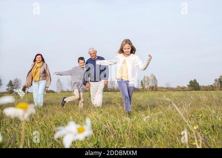 Großeltern mit Enkelkindern verbringen Freizeit auf dem Feld gegen den Himmel Am Wochenende Stockfoto