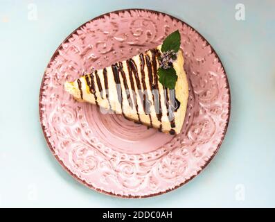 Ein Stück Käsekuchen auf einem rosafarbenen Teller, ein leckeres und gesundes Dessert. Stockfoto