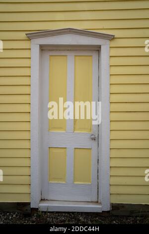 Außenansicht eines gelb gestrichenen Hauses, Tür mit weißen Zierleisten. Aufgenommen in South Park Colorado, einer Geisterstadt Stockfoto