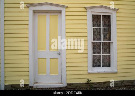 Außenansicht eines gelb gestrichenen Hauses, Tür und Fenster mit weißen Zierleisten. Aufgenommen in South Park Colorado, einer Geisterstadt Stockfoto
