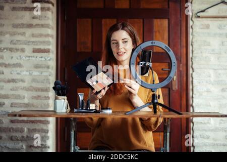 Kosmetikerin macht Make-up Tutorial auf Handy im Stehen Zu Hause Stockfoto
