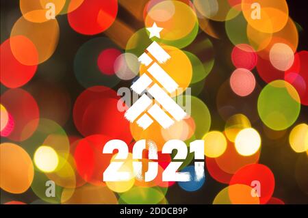 Weihnachtliche Background-Girlanden mit bunten Lichtern auf einem geschmückten Weihnachtsbaum, Bokeh, Happy New Year 2021 farbiges Symbol und Text in trendigen Flatten Stockfoto