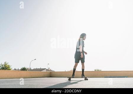 Junger Mann Skating mit Rollschuh auf dem Dach in der Stadt Stockfoto