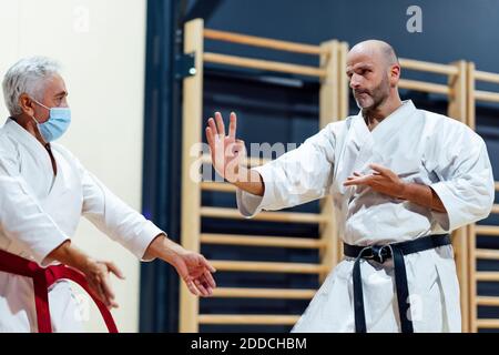 Männlicher Schüler, der Karate vom Lehrer in der Klasse praktiziert Stockfoto