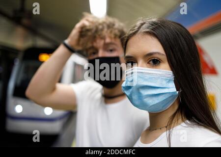 Ein Paar mit Gesichtsmasken steht an der U-Bahn-Station Stockfoto