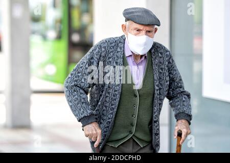 Älterer Mann mit Schutzmaske und Gehstock Im Freien Stockfoto