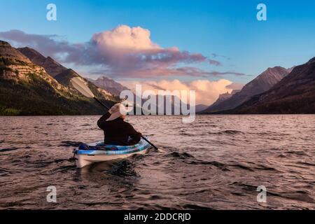 Abenteuerlicher Mann Kajakfahren in Glacier Lake Stockfoto