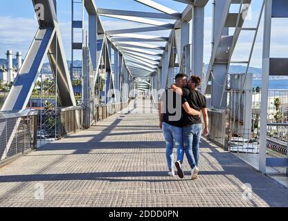 Homosexuelles Paar küssen beim Gehen auf Brücke während sonnigen Tag Stockfoto
