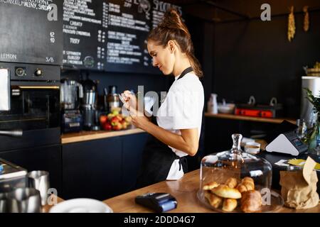 Der Barista schreibt im Notizblock, während er im Café arbeitet Stockfoto