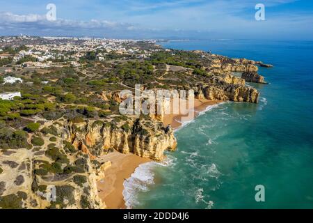 Portugal, Faro District, Albufeira, Drohne Blick auf Praia da Mare das Porcas, Praia da Coelha und die umliegenden Klippen mit Stadt im Hintergrund Stockfoto