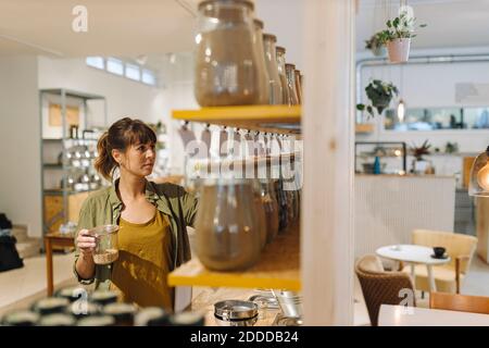 Weibliche Unternehmerin arrangiert Glas im Café Stockfoto