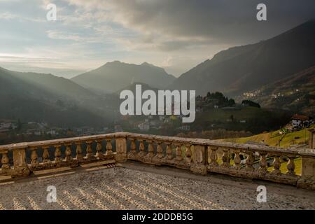 Steinplatz mit Balustrade mit Blick auf ein kleines Bergdorf Stockfoto