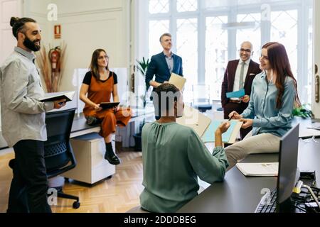 Lächelnde Unternehmer diskutieren Geschäftsstrategien am Arbeitsplatz Stockfoto