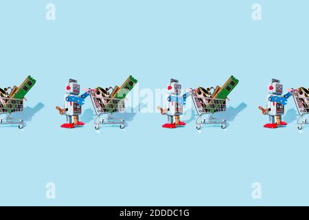 Studio-Aufnahme von Vintage Roboter Spielzeug schieben Miniatur-Einkaufswagen Gefüllt mit elektronischen Geräten Stockfoto