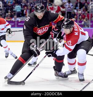 KEIN FILM, KEIN VIDEO, KEIN TV, KEIN DOKUMENTARFILM - Kanadas Stürmer Ryan Getzlaf (15) und Österreichs Stürmer Michael Raffl (12) kämpfen um den Puck während der ersten Periode in einem Herren-Hockey-Spiel bei den Olympischen Winterspielen in Sotschi, Russland, Freitag, 14. Februar 2014. Kanada besiegte Österreich mit 6:0. Foto von Harry E. Walker/MCT/ABACAPRESS.COM Stockfoto