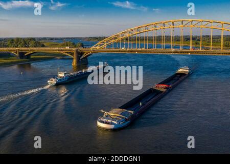 Niederlande, Gelderland, Nijmegen, Luftaufnahme von Barge und Containerschiff unter Brücke auf dem Fluss Waal segeln Stockfoto