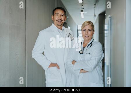 Selbstbewusster Arzt und Wissenschaftler, der am Klinikkorridor steht Stockfoto
