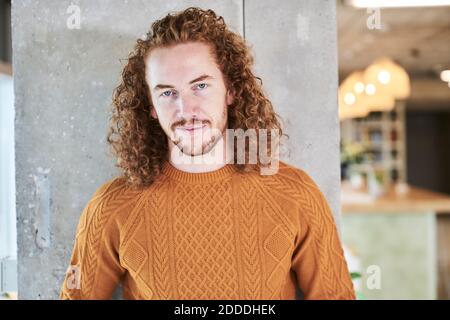 Rotschopf Hipster Mann steht gegen graue Säule zu Hause Stockfoto