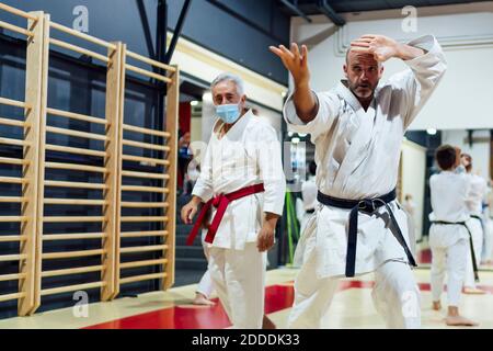 Lehrer von männlichen Studenten üben Karate in der Klasse Stockfoto